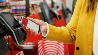 A woman at a Target store uses tap-to-pay
